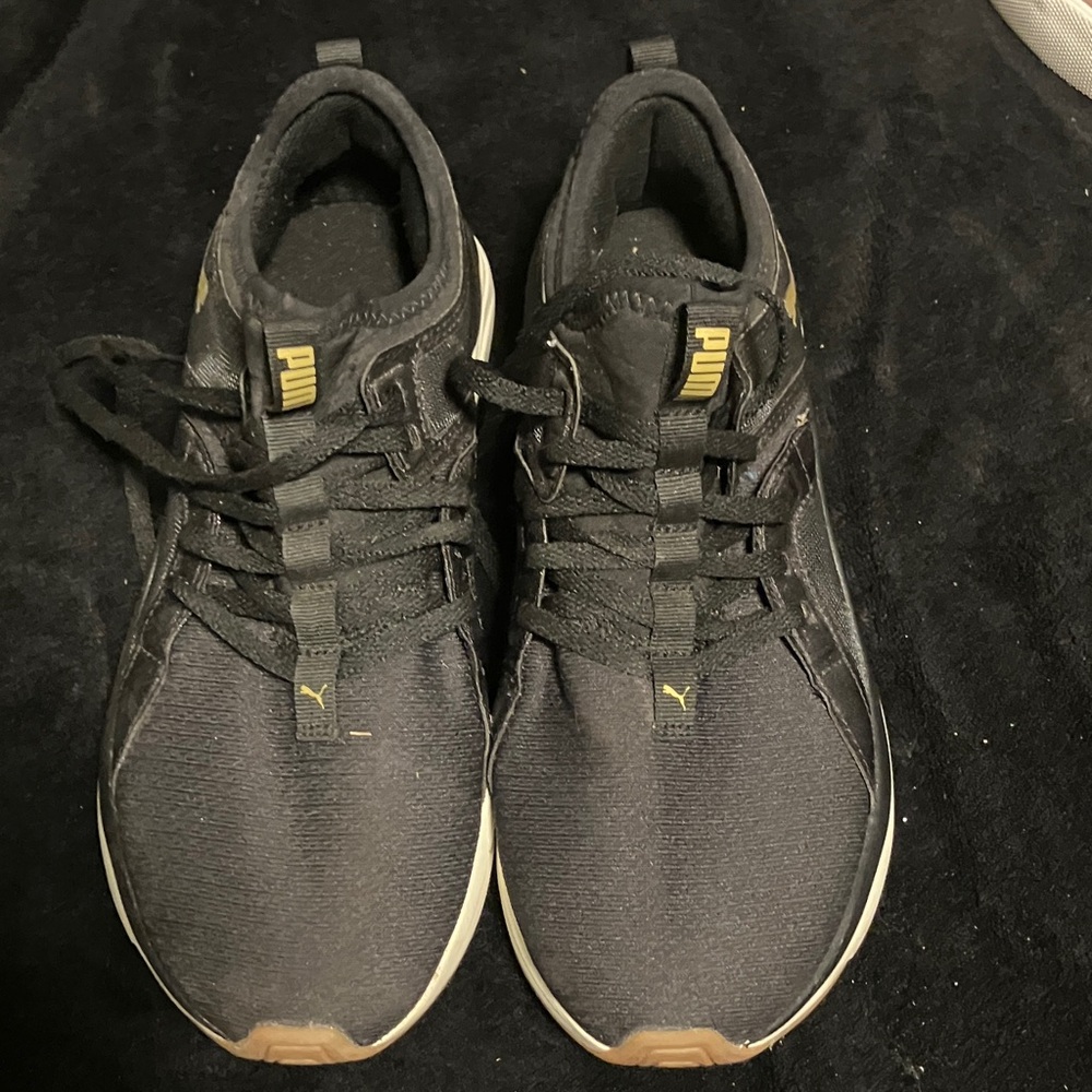 Puma women’s Black and Gold Sneakers